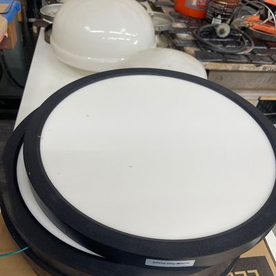 Sale Photo Thumbnail #58: Stack of modern round LED flush-mount ceiling lights with black trim, alongside vintage white glass light globes in the background.