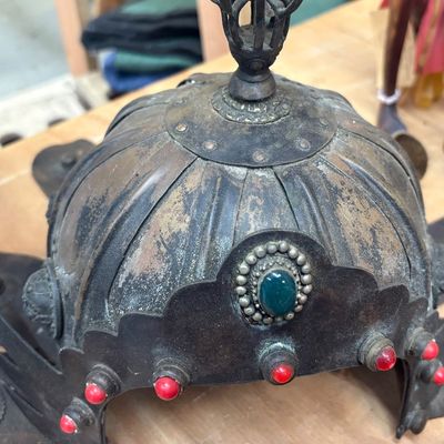 Sale Photo Thumbnail #8: Antique Chinese  ceremonial metal helmet featuring a finial top, fluted dome, and beaded rim set with green cabochons and red accent stones.