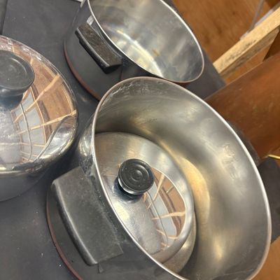 Sale Photo Thumbnail #17: Selection of vintage Revere Ware copper-bottom pots and pans featuring black Bakelite handles.