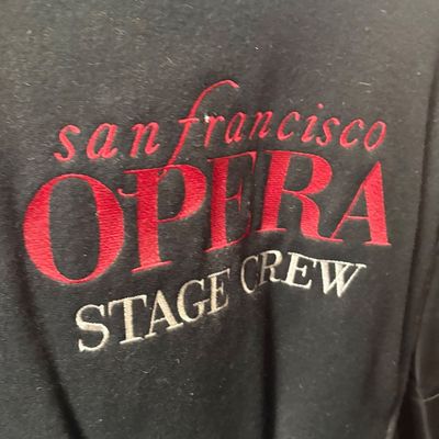 Sale Photo Thumbnail #30: Black garment featuring embroidered red and white lettering reading "san francisco OPERA STAGE CREW".