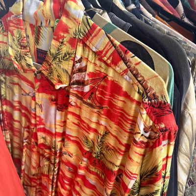 Sale Photo Thumbnail #32: Vintage Jack's of Hollywood Hawaiian shirt featuring a vibrant red and yellow tropical sunset print with palm trees and sailboats.