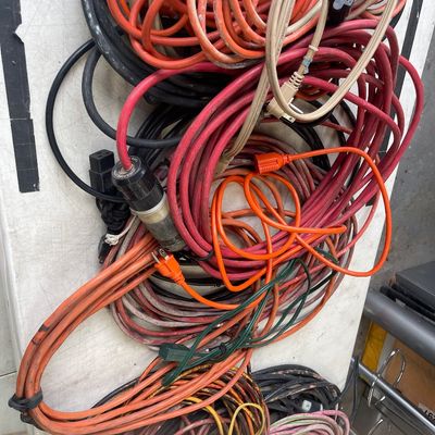 Sale Photo Thumbnail #60: Large assortment of heavy-duty outdoor and indoor extension cords in various lengths and gauges.