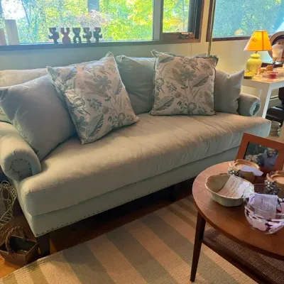 Beautiful, elegant sofa upholstered in a soft, pale blue-green fabric, featuring classic rolled arms, nail head trim with pillows that...