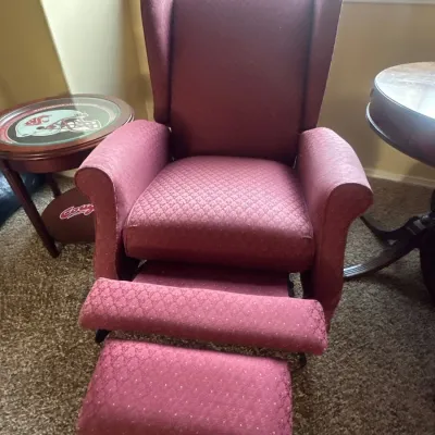 Wingback armchair in recliner position showing extended footrest.