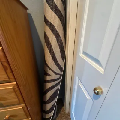 Rolled area rug featuring a black and beige zebra print pattern