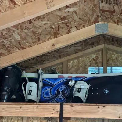 Snowboards alongside a pair of black Salomon ski boots.
