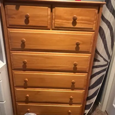 Tall chest of drawers featuring two upper small drawers above five full-width drawers with matching wooden knobs.