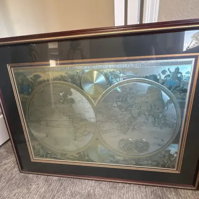 Framed foil art print featuring a vintage dual-hemisphere world map set within a dark mat and wooden frame.