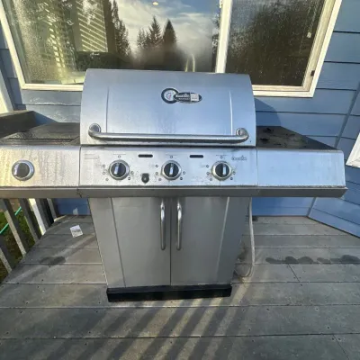 Char-Broil Gourmet stainless steel gas grill with lower cabinet storage and side burner.