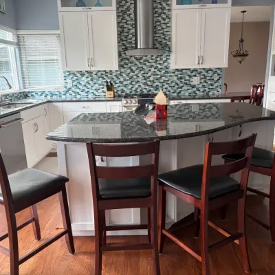 Set of four modern wooden barstools with black seats and ladder style back.