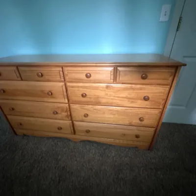 Traditional style eight-drawer dresser with wooden knobs and a natural light finish.