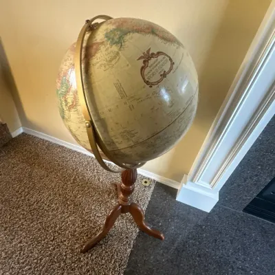 Replogle 16-inch diameter floor-standing world globe on a turned wooden tripod base with a brass-finished full meridian.