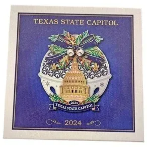 Official 2024 Texas State Capitol collectible Christmas ornament, mounted on its original blue presentation card.