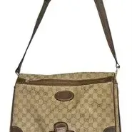 Vintage Gucci GG monogram canvas messenger bag featuring dark brown leather trim and an adjustable shoulder strap.