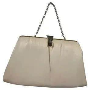 Vintage white leather or vinyl clutch purse featuring a silver-tone chain strap and gold-tone clasp accent, mid-20th century.
