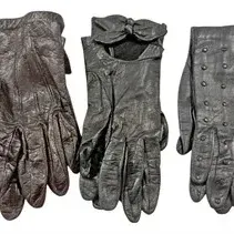 Collection of three pairs of vintage black leather gloves, featuring classic tailored styles, a bow-accented pair, and a stud-embellished...
