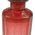 Vintage pink glass perfume bottle featuring a paneled body and a clear faceted crystal stopper.
