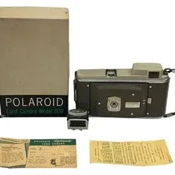 Vintage Polaroid Highlander Land Camera Model 80B with original box, light meter accessory, and instruction manuals, circa 1950s.