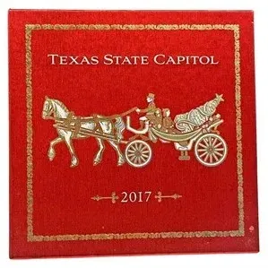 Official 2017 Texas State Capitol ornament in its original red presentation box with gold foil lettering and horse-drawn carriage graphics.