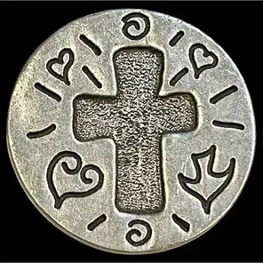 Round pewter religious pocket token featuring a textured central cross surrounded by hearts, a dove, and swirl motifs.