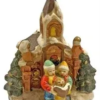 Painted ceramic Christmas village church figurine featuring carolers singing in front of a snow-dusted church.