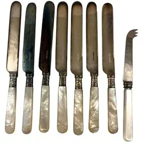 Set of eight antique mother-of-pearl handled knives, including seven dinner knives with silver-plated blades and one cheese knife.