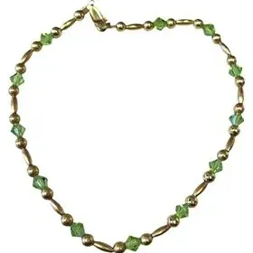 Gold-tone beaded anklet or bracelet featuring alternating metal beads and green faceted crystal accents.