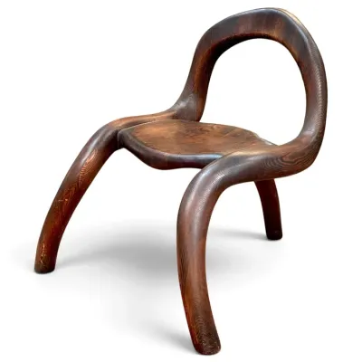 Sale Photo Thumbnail #152: Sculptural hand-carved dark wood accent chair featuring continuous organic lines and curved legs.
