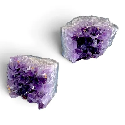 Sale Photo Thumbnail #175: Pair of natural amethyst geode quartz cluster bookends displaying deep purple crystalline interiors and polished outer edges.