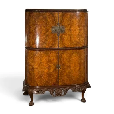 Sale Photo Thumbnail #121: Antique Queen Anne style walnut burl cabinet on stand, featuring ornate brass hardware, carved apron, and claw-and-ball feet.