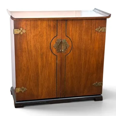 Sale Photo Thumbnail #141: Asian-style wooden cabinet featuring ornate brass hardware, a flared pagoda-style top, and a contrasting dark base.