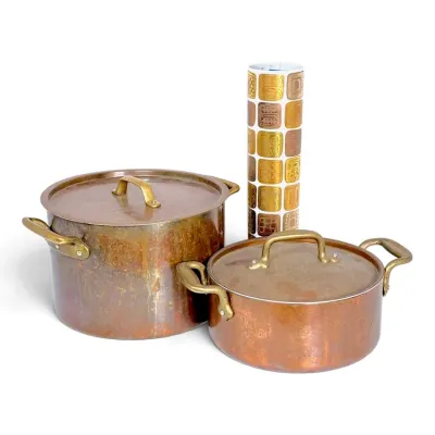 Sale Photo Thumbnail #228: Two vintage copper stockpots with brass handles and matching lids, displayed alongside a tall ceramic vase featuring a mid-century geometric pattern.