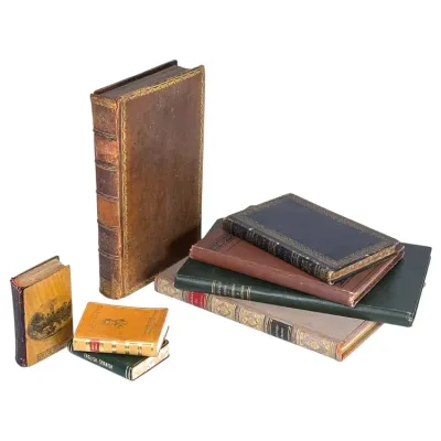 Sale Photo Thumbnail #166: Collection of antique and vintage hardbound books, including gilt-embossed leather bindings and miniature volumes, showing age-appropriate shelf wear.