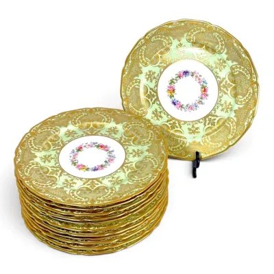 Sale Photo Thumbnail #210: Set of porcelain cabinet plates featuring pale green grounds, intricate gilded scrollwork borders, and central floral wreath motifs.
