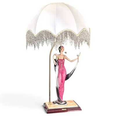 Sale Photo Thumbnail #183: Art Deco style flapper table lamp featuring a figurine in a pink gown on a wooden base with a beaded fringe shade.