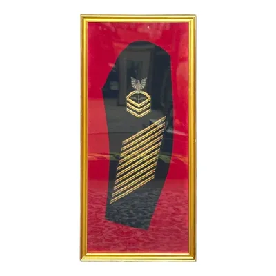 Sale Photo Thumbnail #78: Framed US Navy Master Chief Petty Officer sleeve patch featuring gold bullion embroidery and service stripes mounted on a red velvet backing in a gilt frame.
