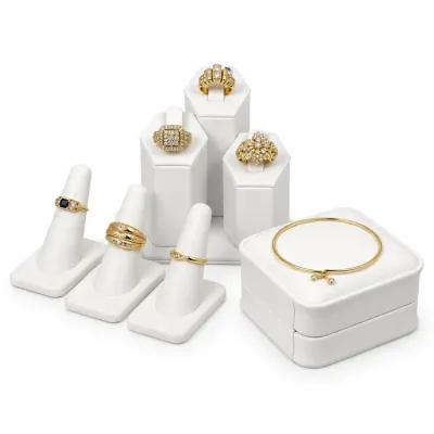 Sale Photo Thumbnail #6: Collection of fine Vintage 14k and 18K jewelry displayed on white leatherette stands, including six diamond- and gemstone-accented rings and a thin gold bangle bracelet.