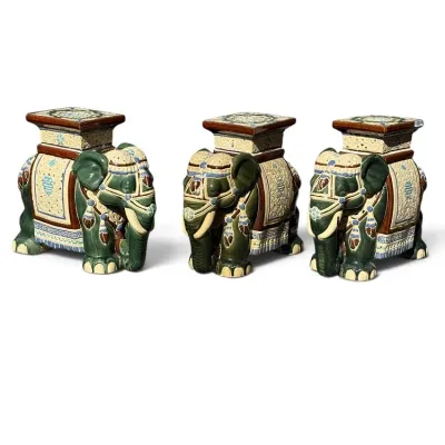 Sale Photo Thumbnail #240: Set of three vintage glazed ceramic elephant garden stools featuring intricate relief details in green, cream, and brown glaze.