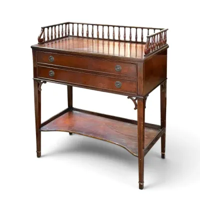 Sale Photo Thumbnail #120: Antique mahogany server or washstand featuring a spindle gallery, two drawers with brass ring pulls, inlaid legs, and a lower shelf.