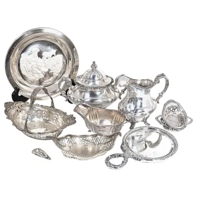 Sale Photo Thumbnail #159: Collection of antique and vintage silver-plated hollowware and vanity pieces, including tea service items, pierced baskets, a repoussé wall plate, and a hand mirror.
