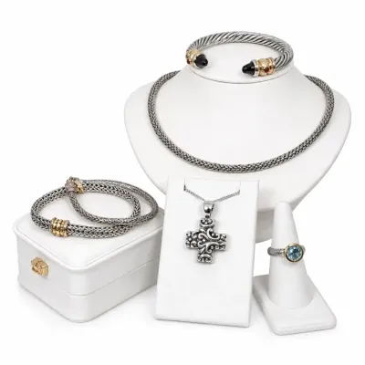 Sale Photo Thumbnail #11: Collection of David Yurman and designer-style sterling silver and 14K/18K gold jewelry, including cable cuff bracelets, a woven chain necklace, a scrollwork cross pendant, and a blue topaz ring.