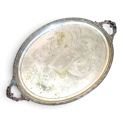Sale Photo Thumbnail #173: Vintage oval silver-plated serving tray featuring etched floral and bird motifs with ornate scrollwork handles.
