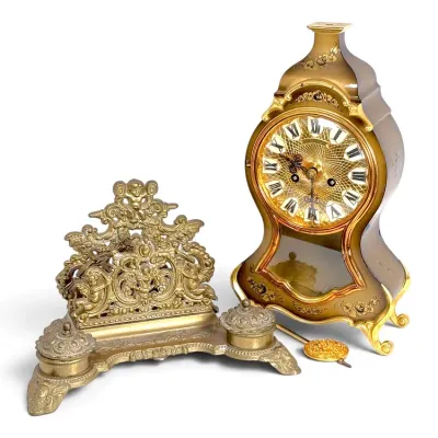 Sale Photo Thumbnail #222: Vintage Rococo revival brass desk set including a mechanical mantel clock with floral gilt accenting and an ornate cherub-themed double inkwell with letter rack.