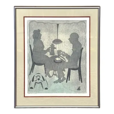 Sale Photo Thumbnail #95: Framed mid-century modern woodcut print depicting a seated couple having coffee with a dog at their feet, housed in a double mat and silver-tone frame.
