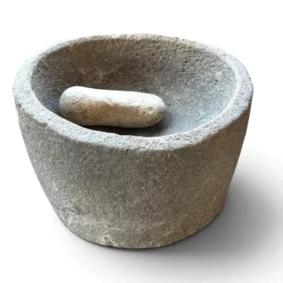 Sale Photo Thumbnail #238: Hand-carved rustic stone mortar and pestle set with a natural rough texture.