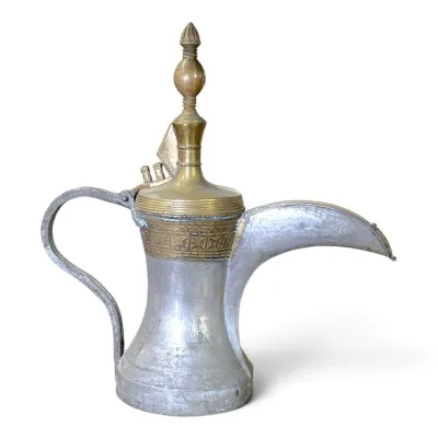 Sale Photo Thumbnail #213: Traditional Middle Eastern brass and tinned copper dallah coffee pot featuring intricate stamped geometric patterns and a tall finial lid.