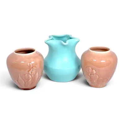 Sale Photo Thumbnail #170: Set of three vintage ceramic art pottery vases, including a pair of dusty pink glazed vases with embossed floral motifs and a central turquoise ruffled rim vase.