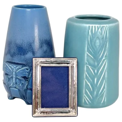 Sale Photo Thumbnail #162: Pair of blue art pottery vases featuring embossed butterfly and stylized leaf designs, paired with a small sterling silver photo frame.