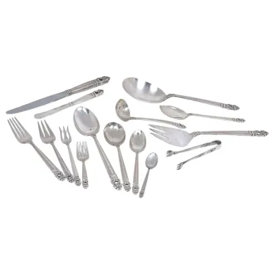Sale Photo Thumbnail #157: Assorted vintage silver-plated or sterling silver flatware pieces, including forks, spoons, knives, serving utensils, and sugar tongs, featuring ornate scrolling handle details.