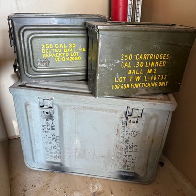 Sale Photo Thumbnail #73: Stack of vintage military surplus metal ammo cans, including two olive drab .30 caliber cans and a larger gray 20mm ammunition crate.